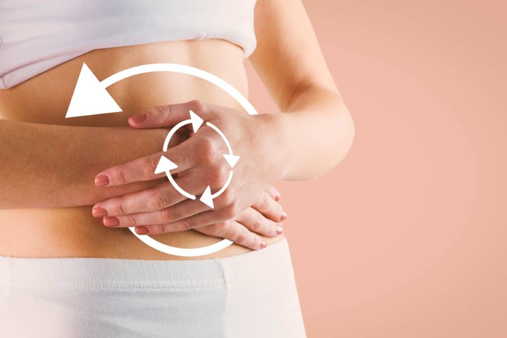 Slim woman touching her belly against orange background