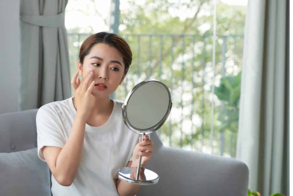 beauty image, Asian woman being concerned with the mirror