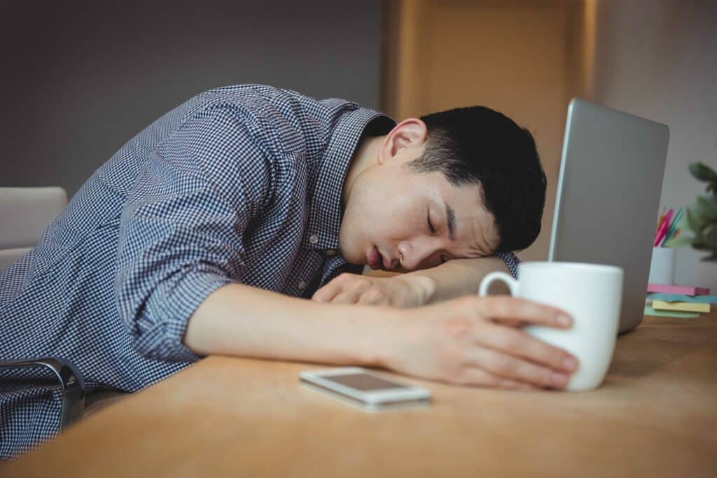 Business executive sleeping at his desk in office