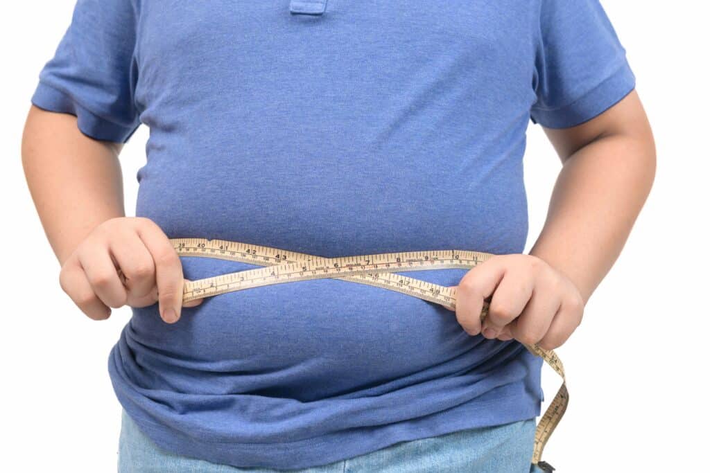 obese fat boy measuring tape of stomach isolated on white backgr